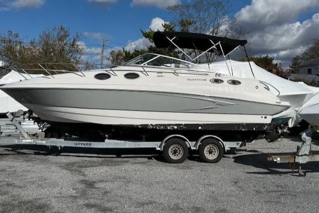 Slide: The Image of 2016 Glastron GS 289 boat on trailer, parked outdoors under cloudy sky. - 8