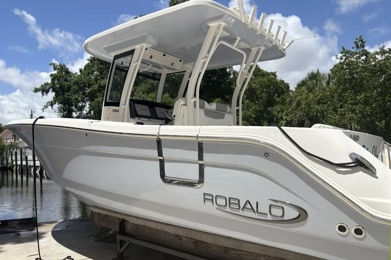 The Image of 2023 Robalo R302 Center Console boat docked under a clear blue sky. - 0