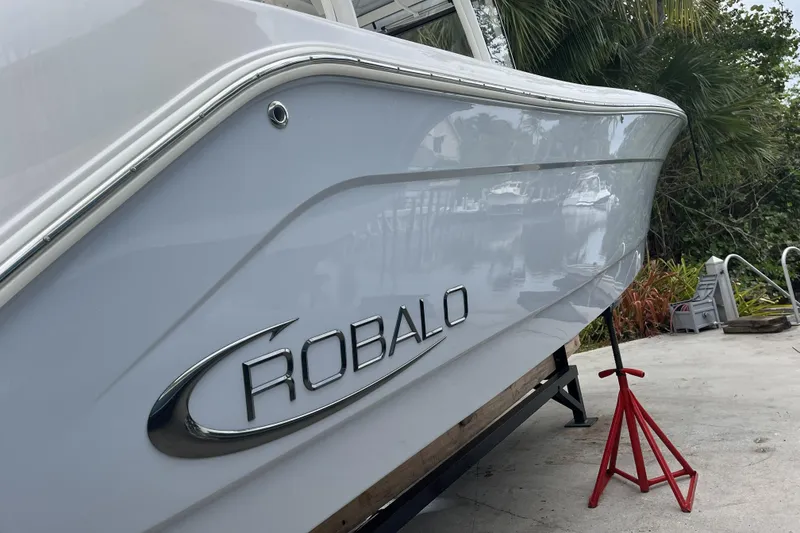 Slide: The Image of 2023 Robalo R302 Center Console boat on stands, side view with logo. - 11