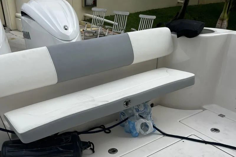 Slide: The Image of 2023 Robalo R302 Center Console boat seating area with white and gray cushions. - 17