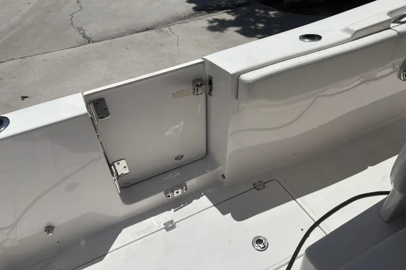 Slide: The Image of 2023 Robalo R302 Center Console boat interior with open hatch and seating area. - 6