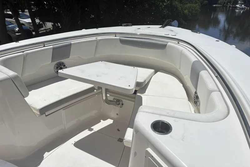 Slide: The Image of 2023 Robalo R302 Center Console boat with white seating and table in the bow area. - 9