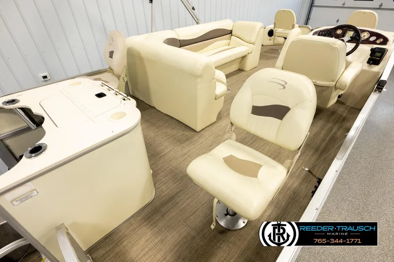 Slide: The Image of 2008 Bennington 2050 FSI boat interior with beige seating and steering console. - 12