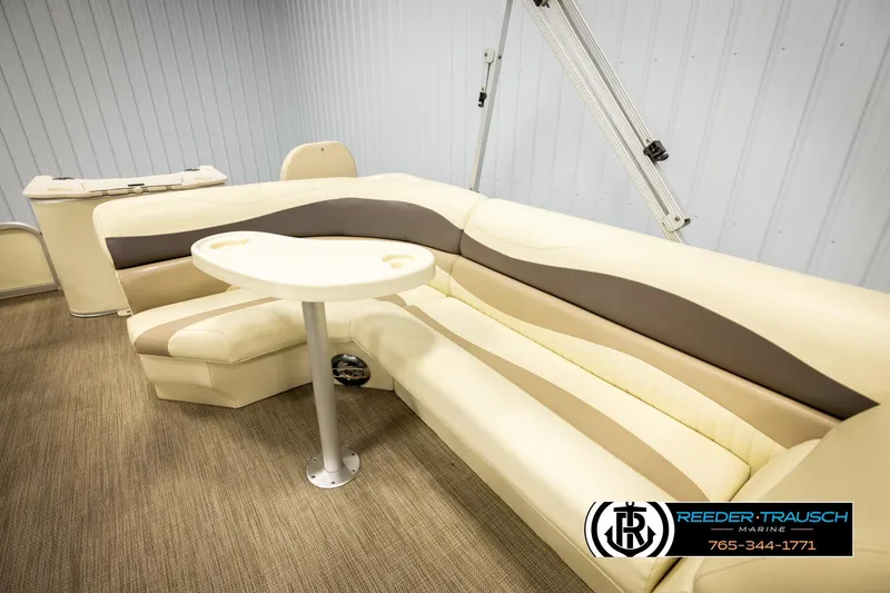 Slide: The Image of 2008 Bennington 2050 FSI boat interior with beige seating and table, Reeder-Trausch Marine logo. - 20