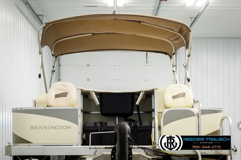Slide: The Image of 2008 Bennington 2050 FSI pontoon boat in a storage facility, featuring beige seating and canopy. - 7
