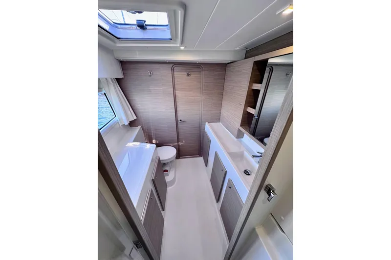 Slide: The Image of 2024 Lagoon 42 yacht bathroom with modern fixtures and skylight. - 21