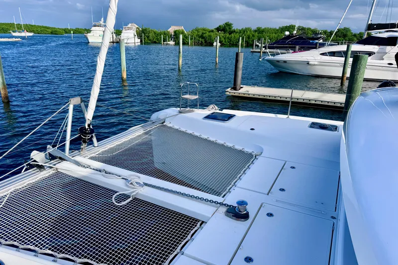 Slide: The Image of 2024 Lagoon 42 catamaran docked in a serene marina setting. - 33