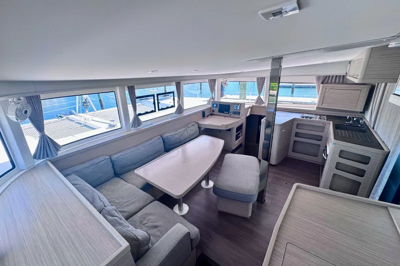 Slide: The Image of Interior of 2024 Lagoon 42 catamaran with modern seating and kitchen area. - 9