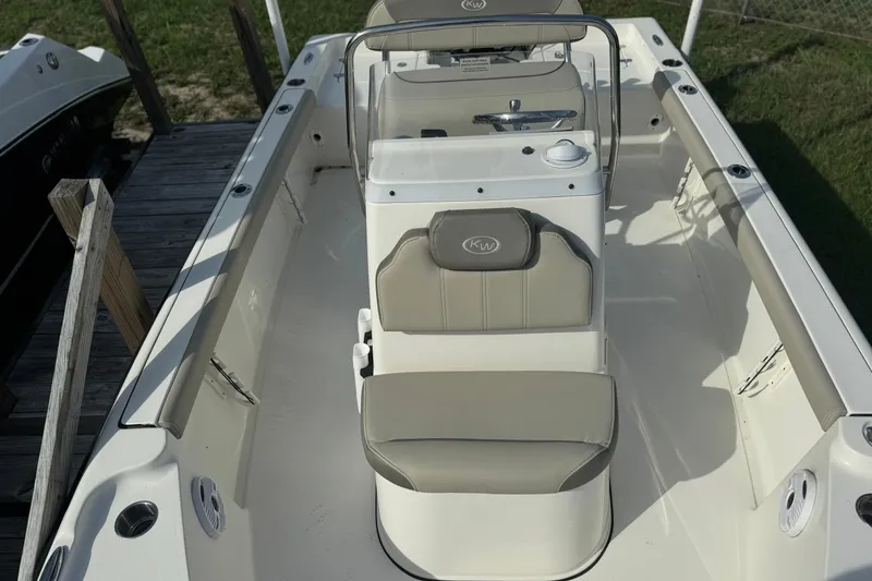 Slide: The Image of 2024 Key West 188 Bay Reef boat interior with seating and console, docked outdoors. - 4