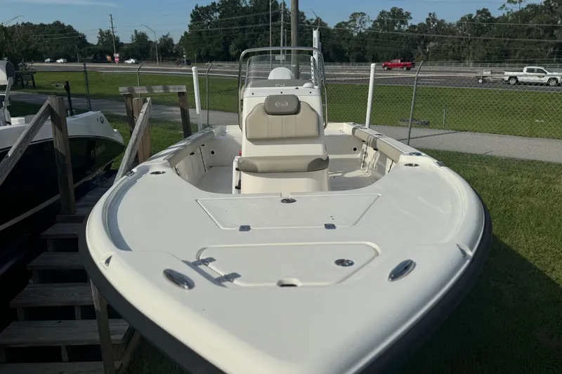 Slide: The Image of 2024 Key West 188 Bay Reef boat, white exterior, parked outdoors near a fence. - 8