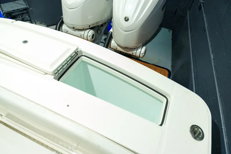 Slide: The Image of 2023 Regulator 28 boat interior with storage compartments and Yamaha engines. - 11