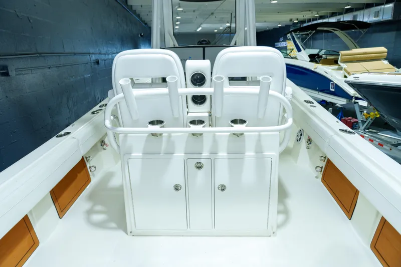Slide: The Image of 2023 Regulator 28 boat interior with open storage compartments and rod holders. - 16