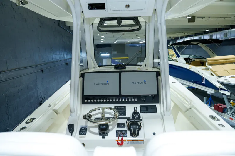 Slide: The Image of 2023 Regulator 28 boat dashboard with Garmin navigation displays and controls. - 20