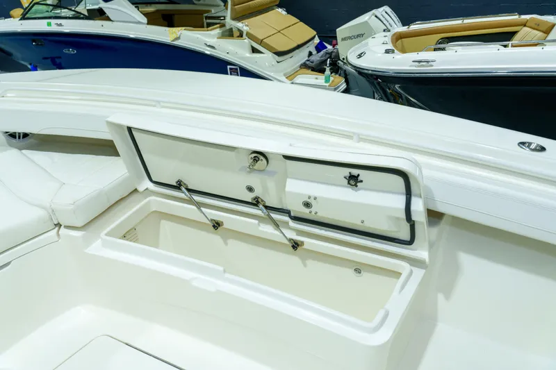 Slide: The Image of 2023 Regulator 28 boat interior with white cushioned seating in a showroom. - 24