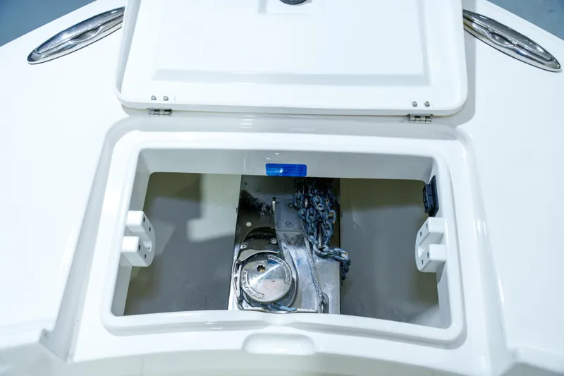 Slide: The Image of 2023 Regulator 28 boat interior with white cushioned seating and open storage compartment. - 28