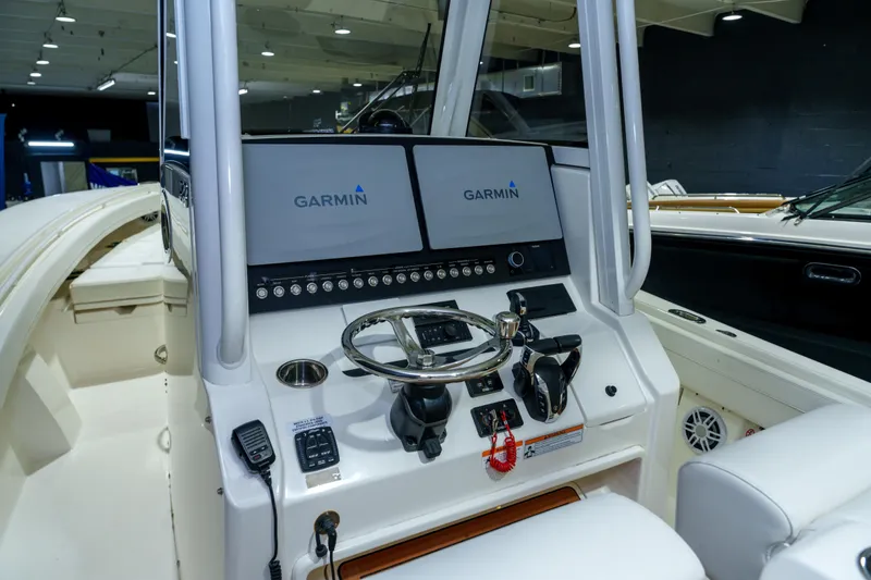 Slide: The Image of 2023 Regulator 28 boat interior with white seating and console in a garage. - 35