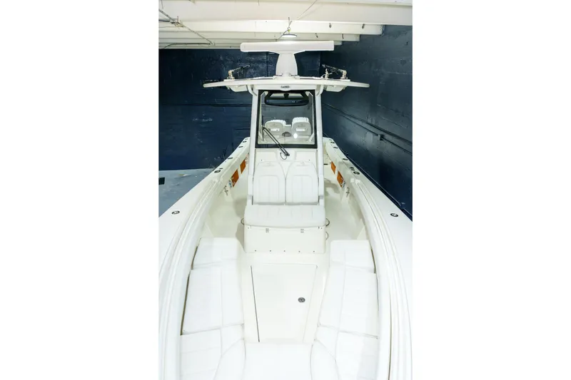 Slide: The Image of 2023 Regulator 28 boat in showroom, blue hull, elevated on stands. - 36