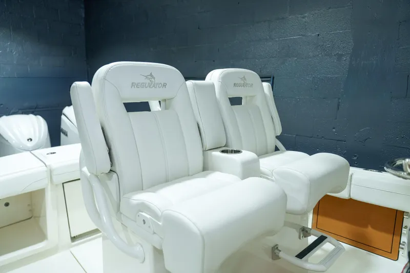 Slide: The Image of 2023 Regulator 28 boat with open storage compartment and dual outboard engines. - 9