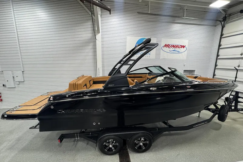 The Image of 2026 Chaparral 6 SSX boat in showroom, black exterior, tan interior, on trailer. - 1
