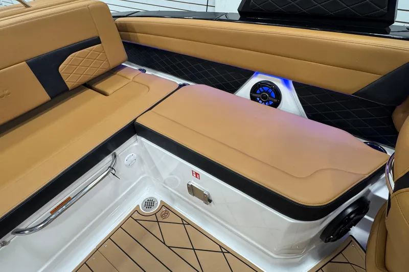 Slide: The Image of 2026 Chaparral 6 SSX boat interior with tan and black seating, featuring a speaker and storage. - 16