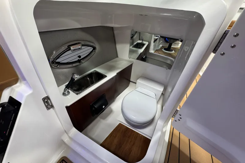 Slide: The Image of 2026 Chaparral 6 SSX boat interior with compact bathroom, featuring a toilet and sink. - 29