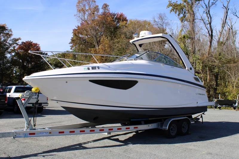 Slide: The Image of 2019 Regal 28 Express boat on trailer, surrounded by autumn trees. - 1