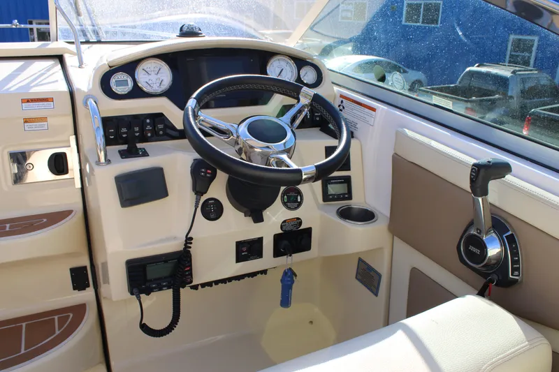 Slide: The Image of 2019 Regal 28 Express boat helm with steering wheel and control panel. - 11
