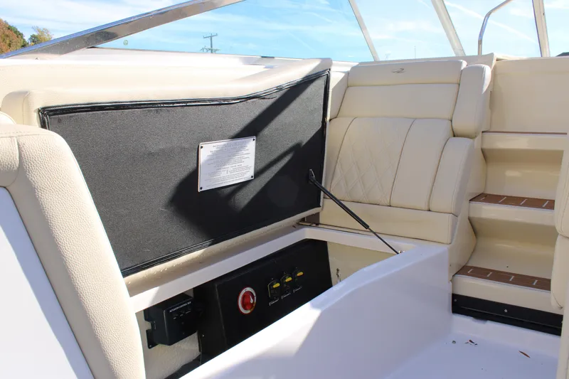 Slide: The Image of 2019 Regal 28 Express boat interior with beige seating and storage compartment. - 13