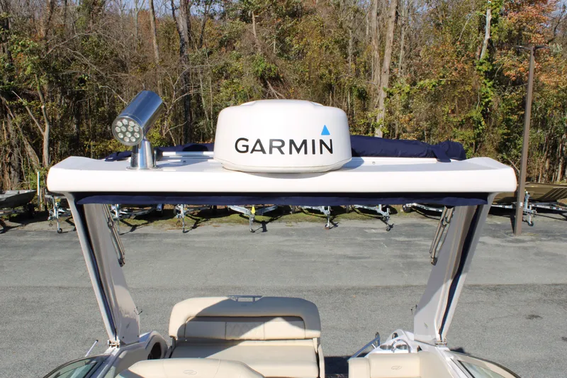 Slide: The Image of 2019 Regal 28 Express boat with Garmin radar, docked near wooded area. - 15