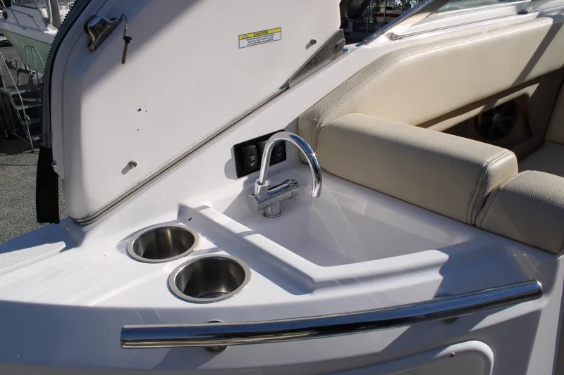 Slide: The Image of 2019 Regal 28 Express boat interior with sink and cup holders. - 16