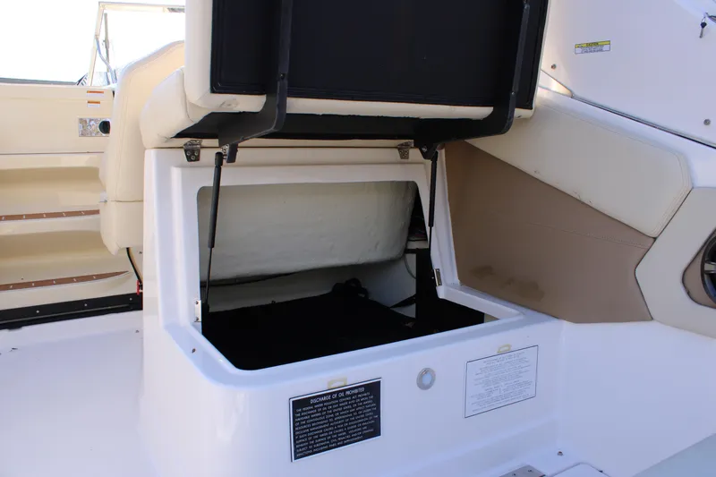 Slide: The Image of 2019 Regal 28 Express boat interior storage compartment open, showcasing spacious design. - 19