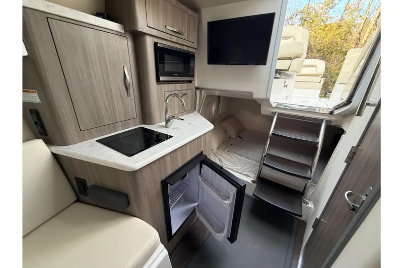 Slide: The Image of 2019 Regal 28 Express boat interior with kitchenette, bed, and stairs. - 23