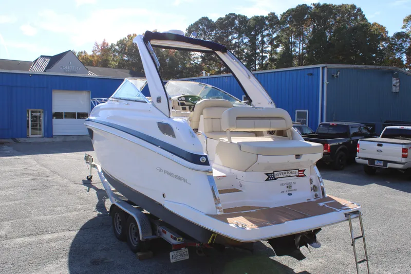 Slide: The Image of 2019 Regal 28 Express boat on trailer outside blue building. - 7