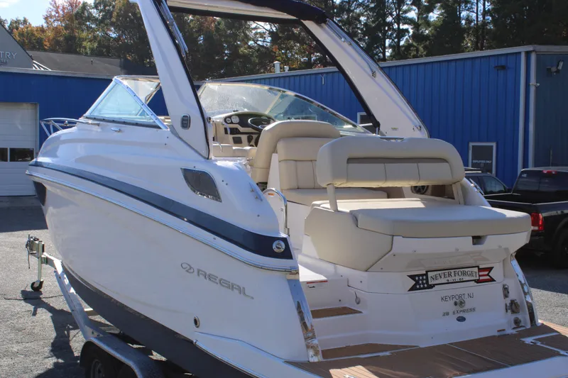 Slide: The Image of 2019 Regal 28 Express boat with sleek design, parked outdoors on a trailer. - 8
