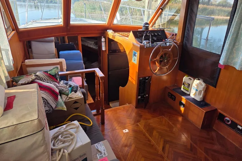 Slide: The Image of 1988 Novamarine 36 Heritage East Trawler interior with wooden helm, seating, and nautical equipment. - 15