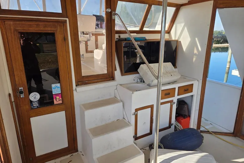 Slide: The Image of 1988 Novamarine 36 Heritage East Trawler interior with wooden accents and compact kitchenette. - 4