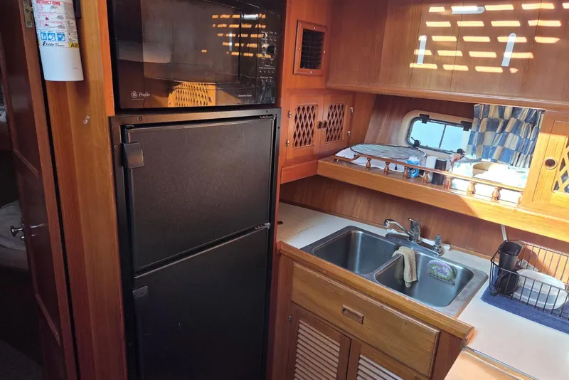 Slide: The Image of 1988 Novamarine 36 Heritage East Trawler kitchen with sink, fridge, and microwave. - 8