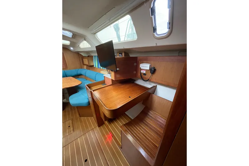 Slide: The Image of Interior of 1999 Hunter Passage 420 sailboat with seating, table, and kitchen area. - 16