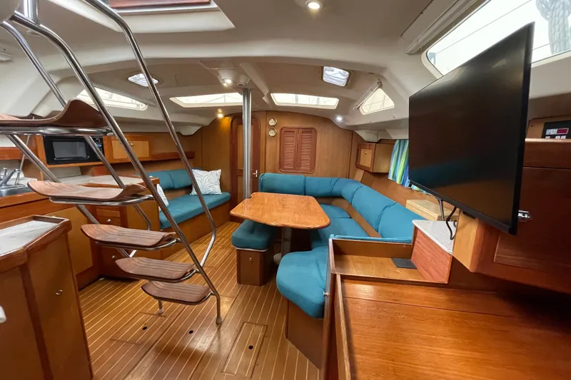 Slide: The Image of Interior of 1999 Hunter Passage 420 sailboat with wood finish and blue seating. - 17