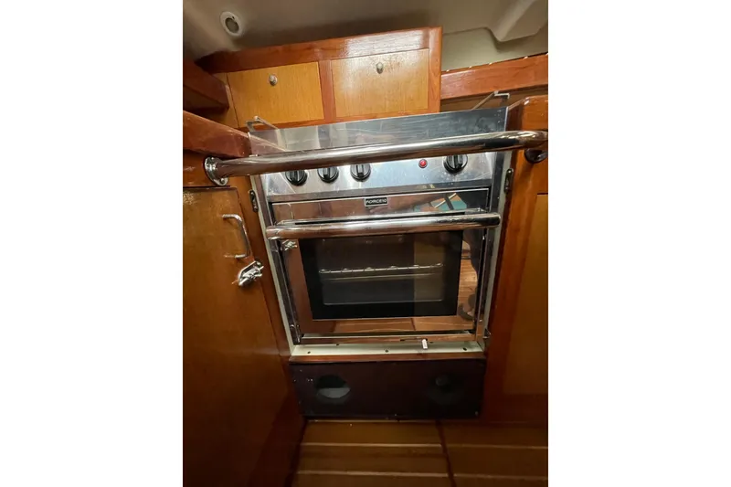 Slide: The Image of 1999 Hunter Passage 420 yacht kitchen with wooden cabinets, stove, and dual sink. - 19