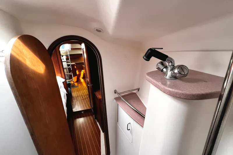 Slide: The Image of Interior of 1999 Hunter Passage 420 yacht, featuring wooden flooring and compact sink area. - 25