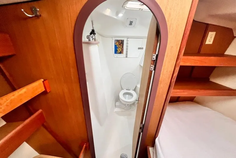 Slide: The Image of 1999 Hunter Passage 420 yacht bathroom with wooden interior and compact design. - 36