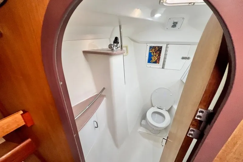Slide: The Image of 1999 Hunter Passage 420 yacht bathroom with toilet and storage shelves. - 37
