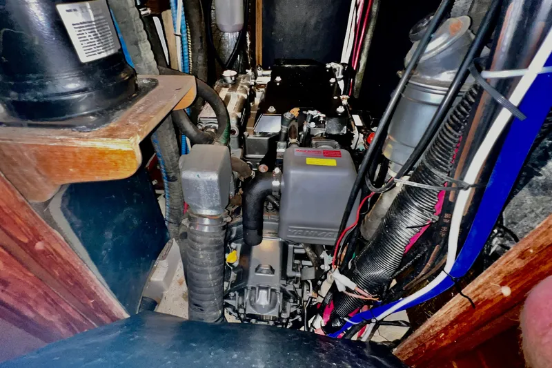 Slide: The Image of Engine compartment of a 1999 Hunter Passage 420 sailboat, showcasing mechanical components and wiring. - 42
