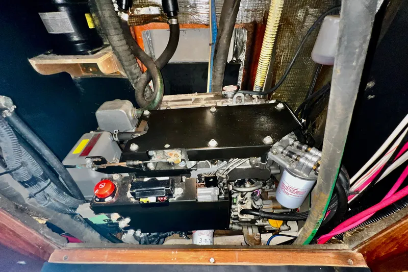 Slide: The Image of Engine compartment of a 1999 Hunter Passage 420 sailboat, showcasing mechanical components and wiring. - 43