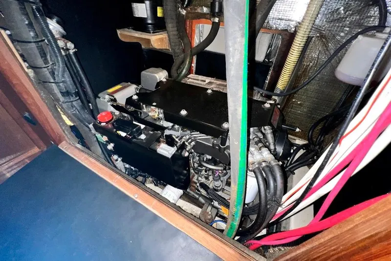 Slide: The Image of Engine compartment of a 1999 Hunter Passage 420 sailboat, showcasing mechanical components and wiring. - 44