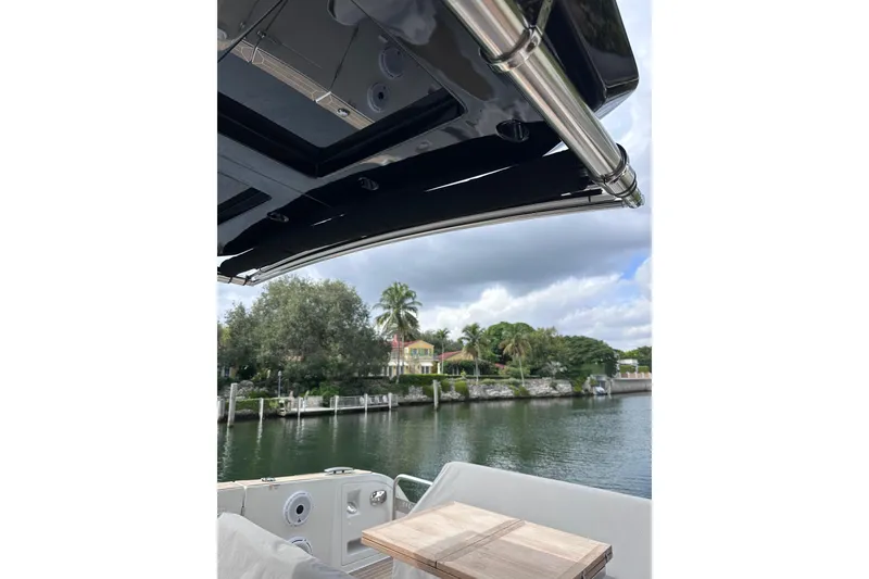 Slide: The Image of 2024 Pardo Yachts P38 interior view with waterfront scenery and lush greenery. - 25