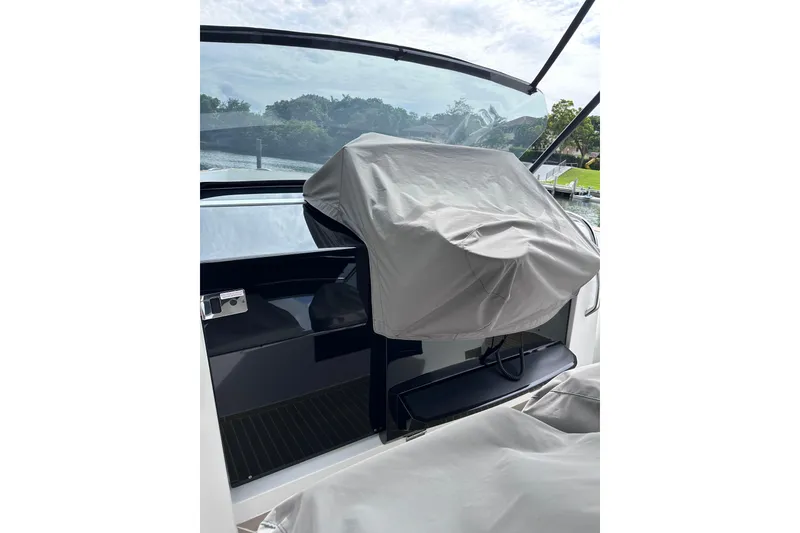 Slide: The Image of 2024 Pardo Yachts P38 cockpit with covered helm station, sleek design, and waterfront view. - 27