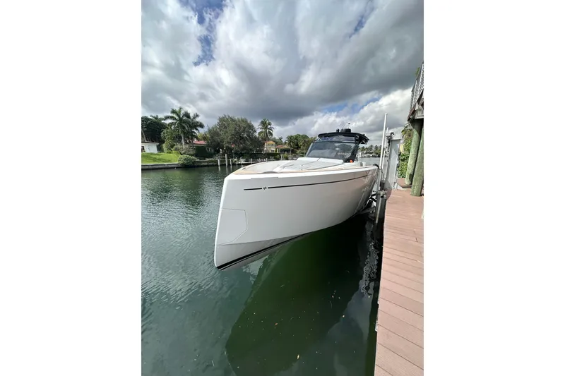 Slide: The Image of 2024 Pardo Yachts P38 docked on a serene waterfront under cloudy skies. - 52