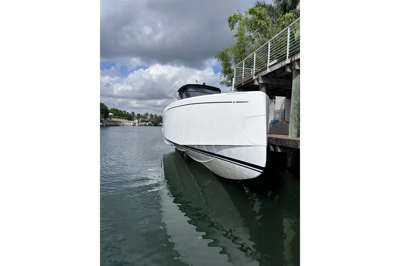 Slide: The Image of 2024 Pardo Yachts P38 docked, sleek white design under cloudy sky. - 55